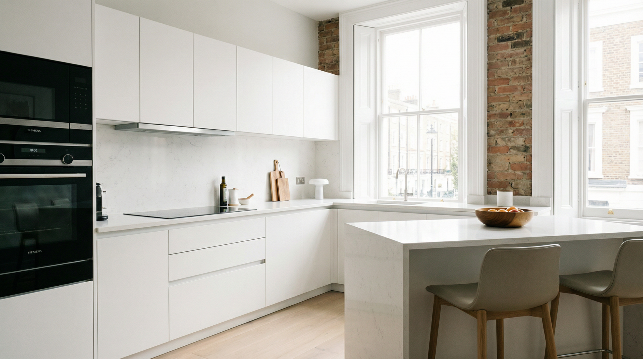 Modern renovated kitchen in a London rental apartment with white cabinets and natural light